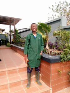 Adeyinka Ayodele on a patio in clothing for landscaping work.