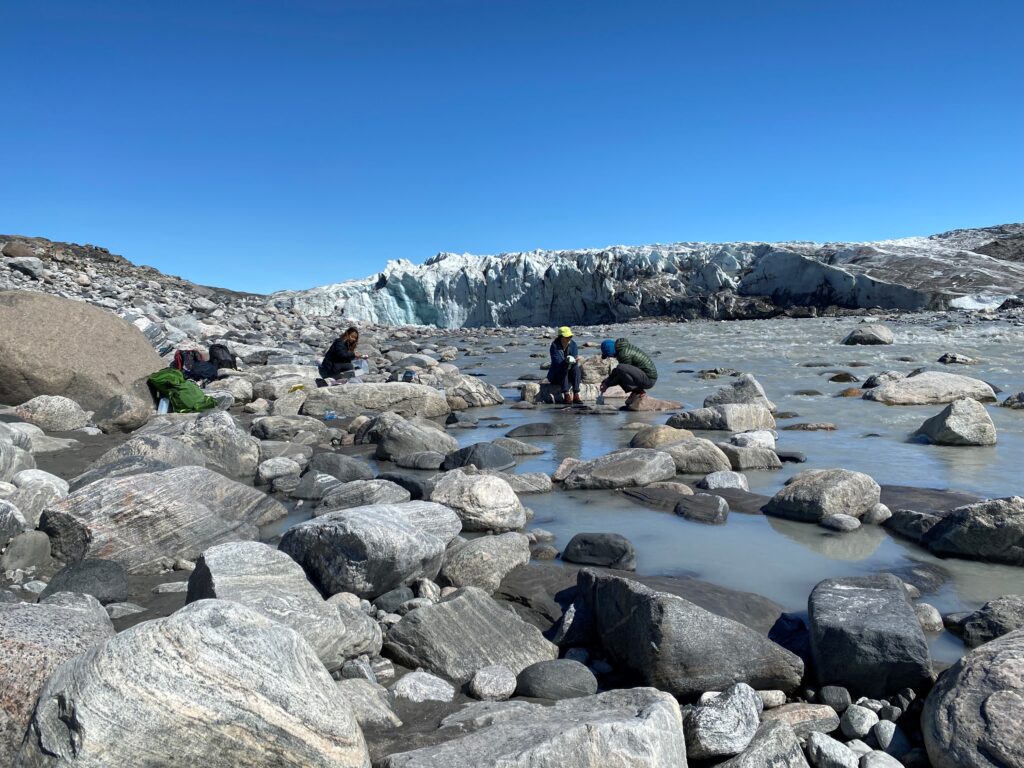 Members of the 2019 WIGF cohort sample water and sediments from the Akuliarusiarsuup River, Greenland near the discharge point of water draining from the Russell outlet glacier of the Greenland Ice Sheet.