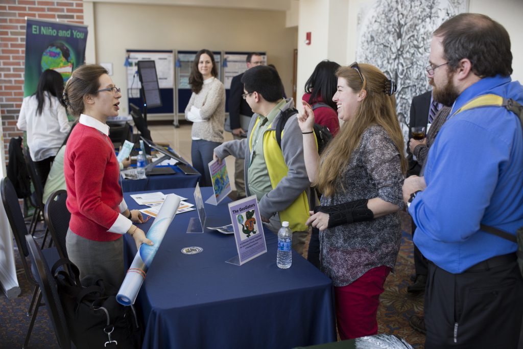 Symposium guests interacting with two display tables